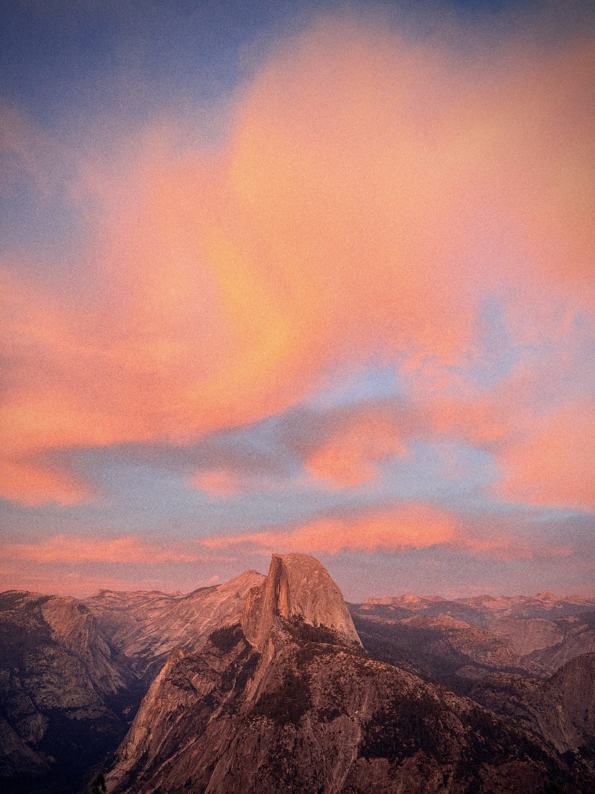 Half Dome at sunset with pink clouds, film grain and halation